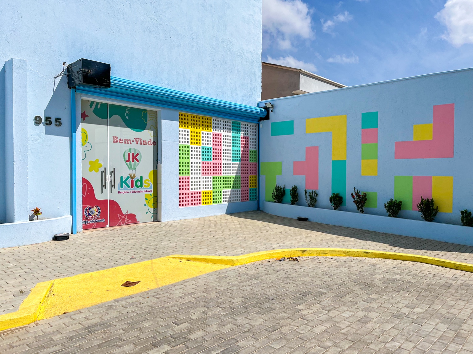 Entrada do JK Kids com porta ilustrada, paredes coloridas e jardim